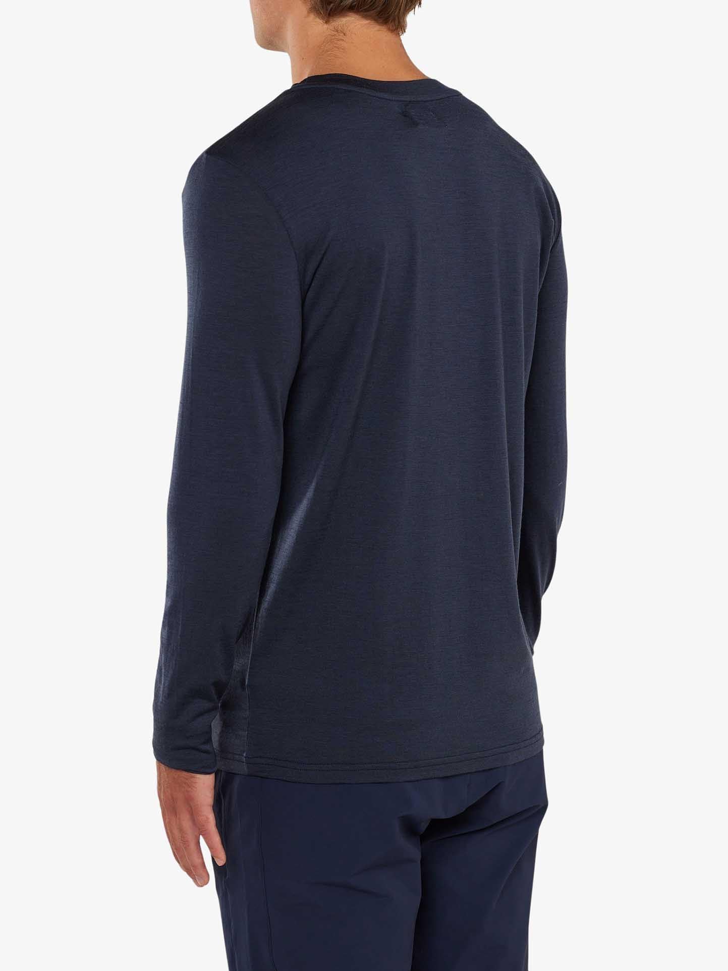 A person with short hair, clad in a long-sleeve Berg LongSleeve Men shirt by We Norwegians and matching dark blue pants, is standing with their back to the camera against a plain white background.