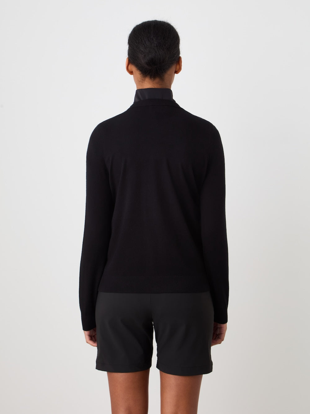 Person wearing black Fairway sweater and black shorts on a white background_Back