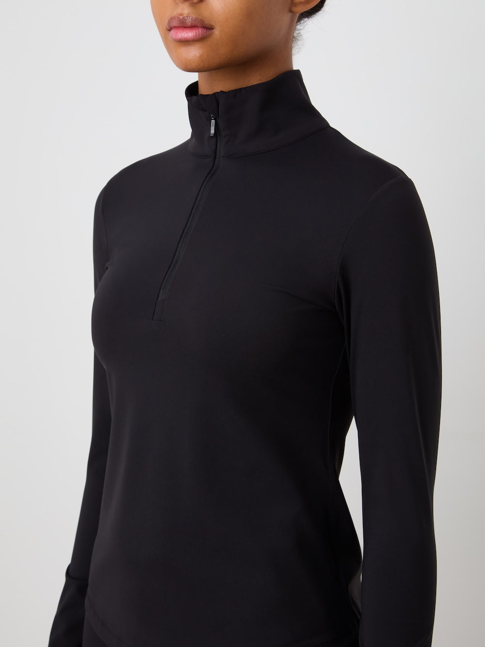 Black long-sleeve top worn by a person on a light background