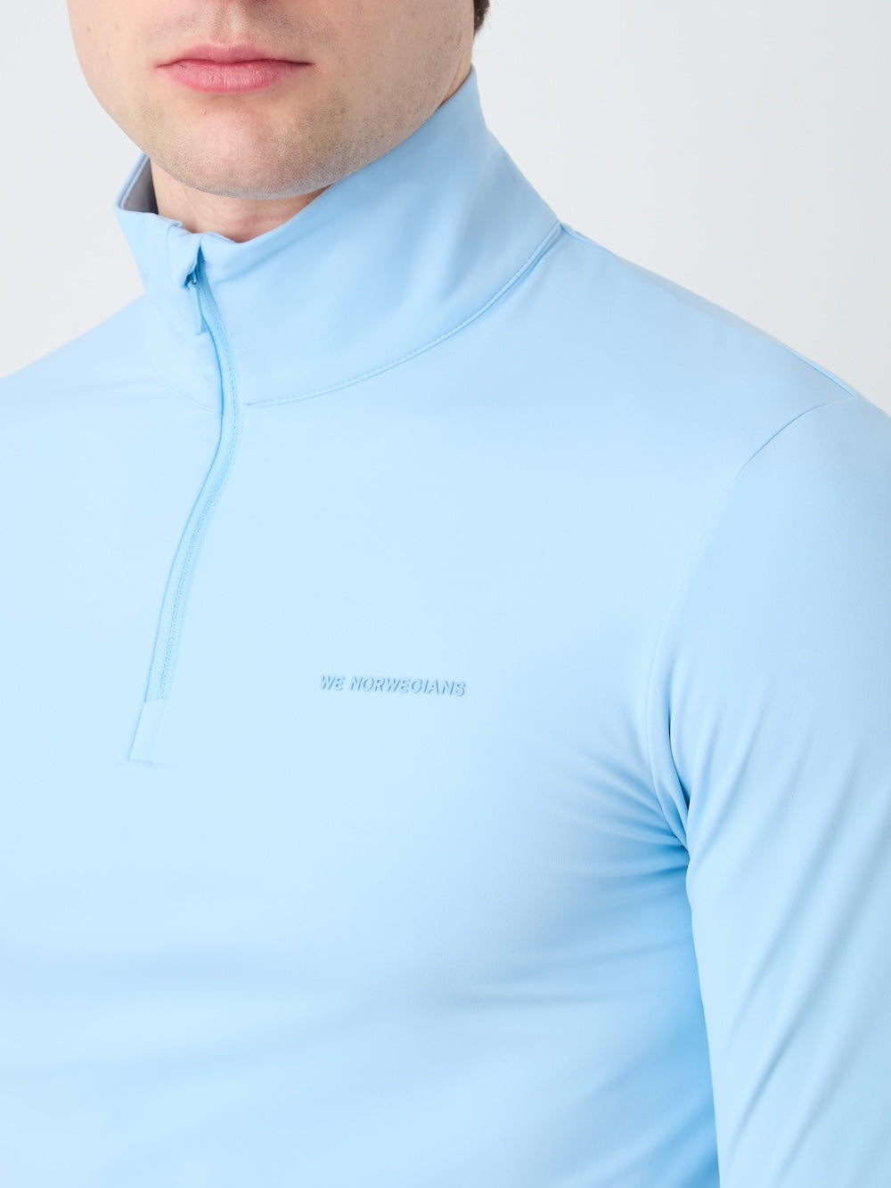 Light blue long-sleeve shirt with a brand logo on a white background