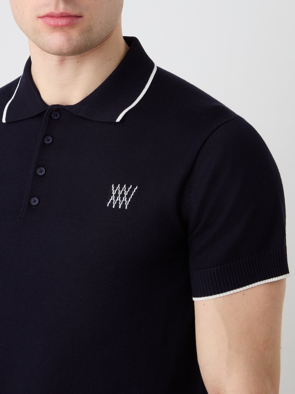 Navy polo shirt with white trim and logo on a plain background
