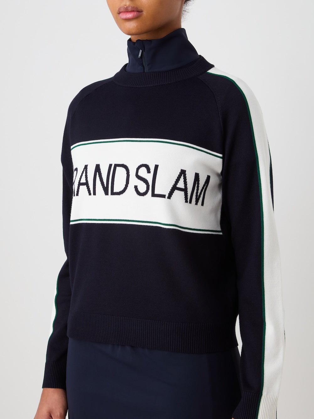 Person wearing a navy blue sweater with "Grand Slam" text in the front, against a light background