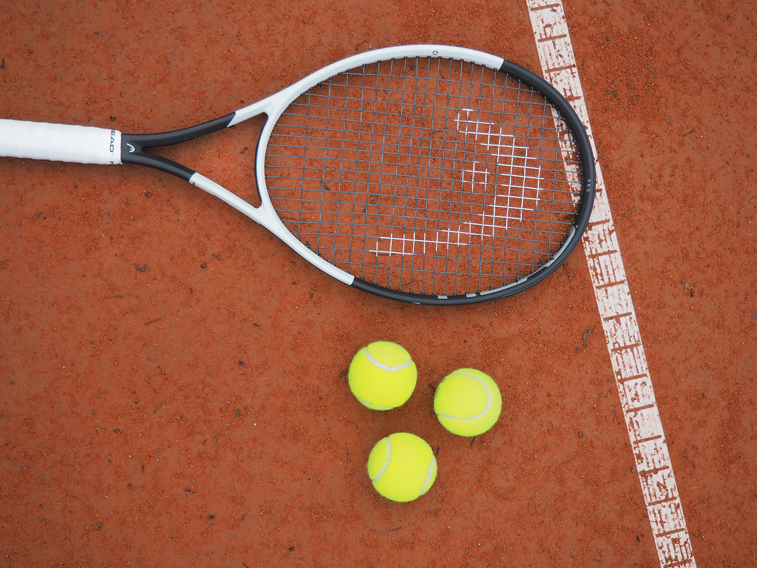 Tennis racket with tennis balls on a tennis court