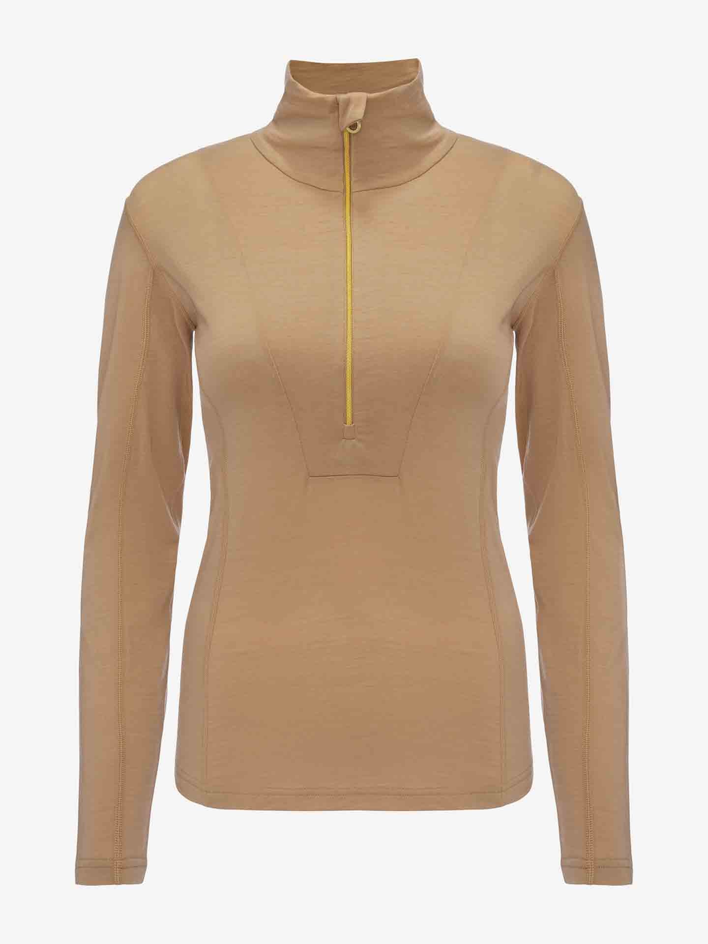 The Sno Merino Zip Up Women by We Norwegians is a beige, long-sleeved shirt made from superfine merino wool, featuring a high neck and a front zipper closure with a striking yellow zipper. It boasts a streamlined, fitted shape with visible stitching along the arms and torso, epitomizing Scandinavian luxury base-layers against a plain white backdrop.