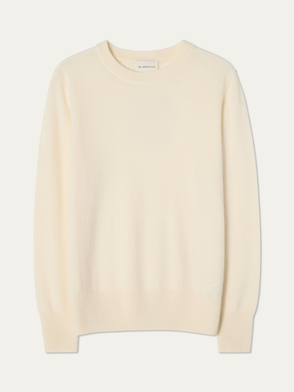 The We Norwegians Blefjell Crewneck Women - Pure Cashmere sweater in cream, featuring long sleeves and a classic crewneck design, is shown laid flat on a white background.