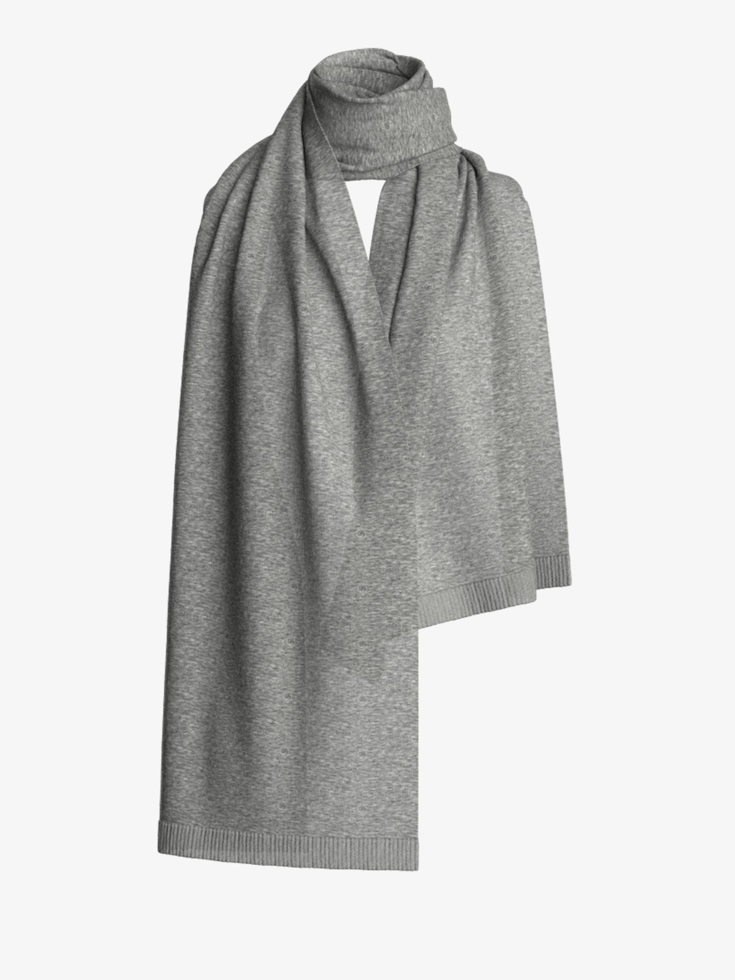 A folded Blefjell Scarf by We Norwegians hangs against a plain background. The soft gray cashmere fabric showcases a ribbed edge along the ends, adding a touch of classic elegance to its design.