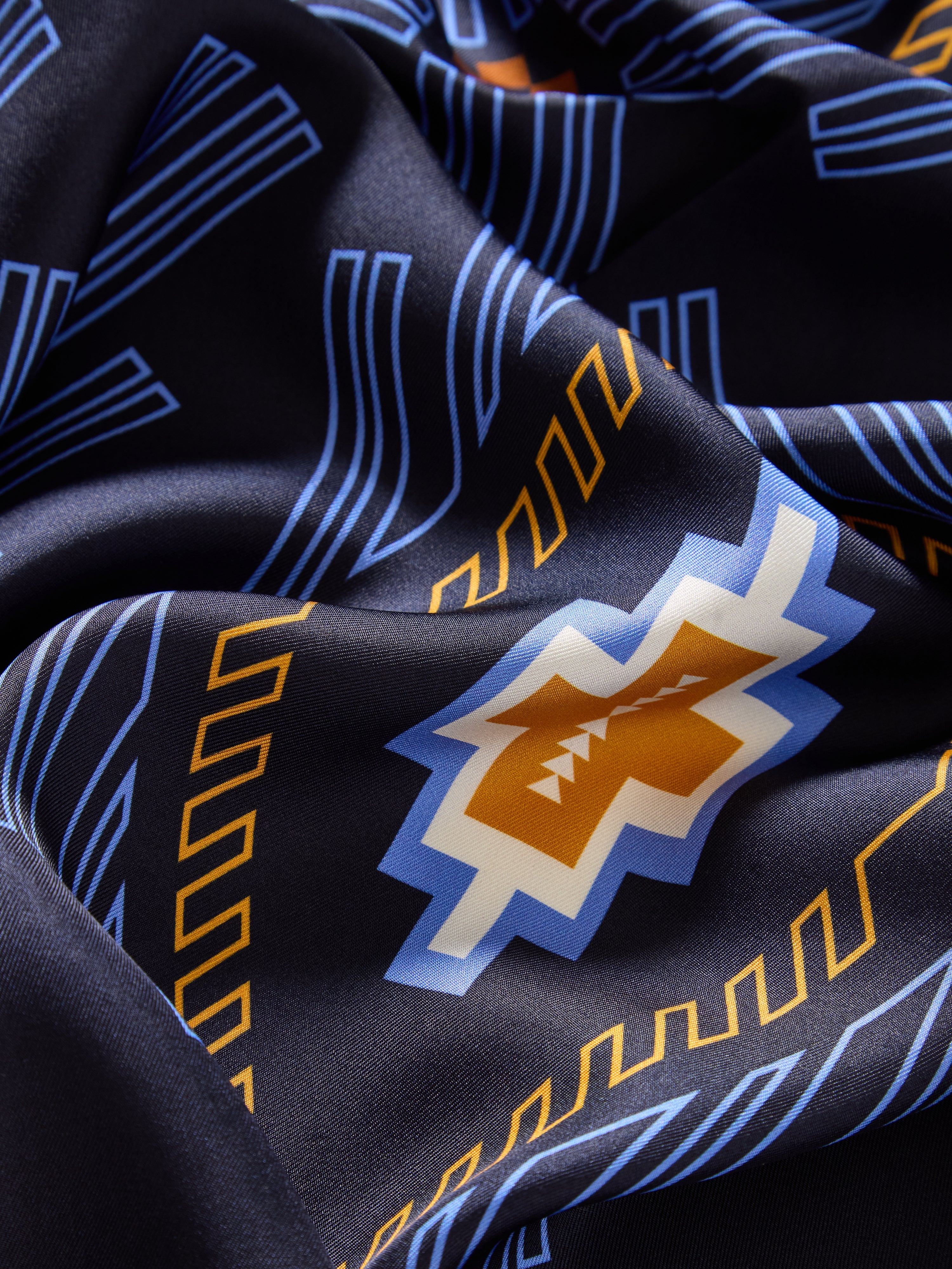 We Norwegians | FW25 | Pioneer Silk Scarf_Navy blue | Scarf with printed motifs inspired by Indigenous American art | Photograph showing the fabric and print details