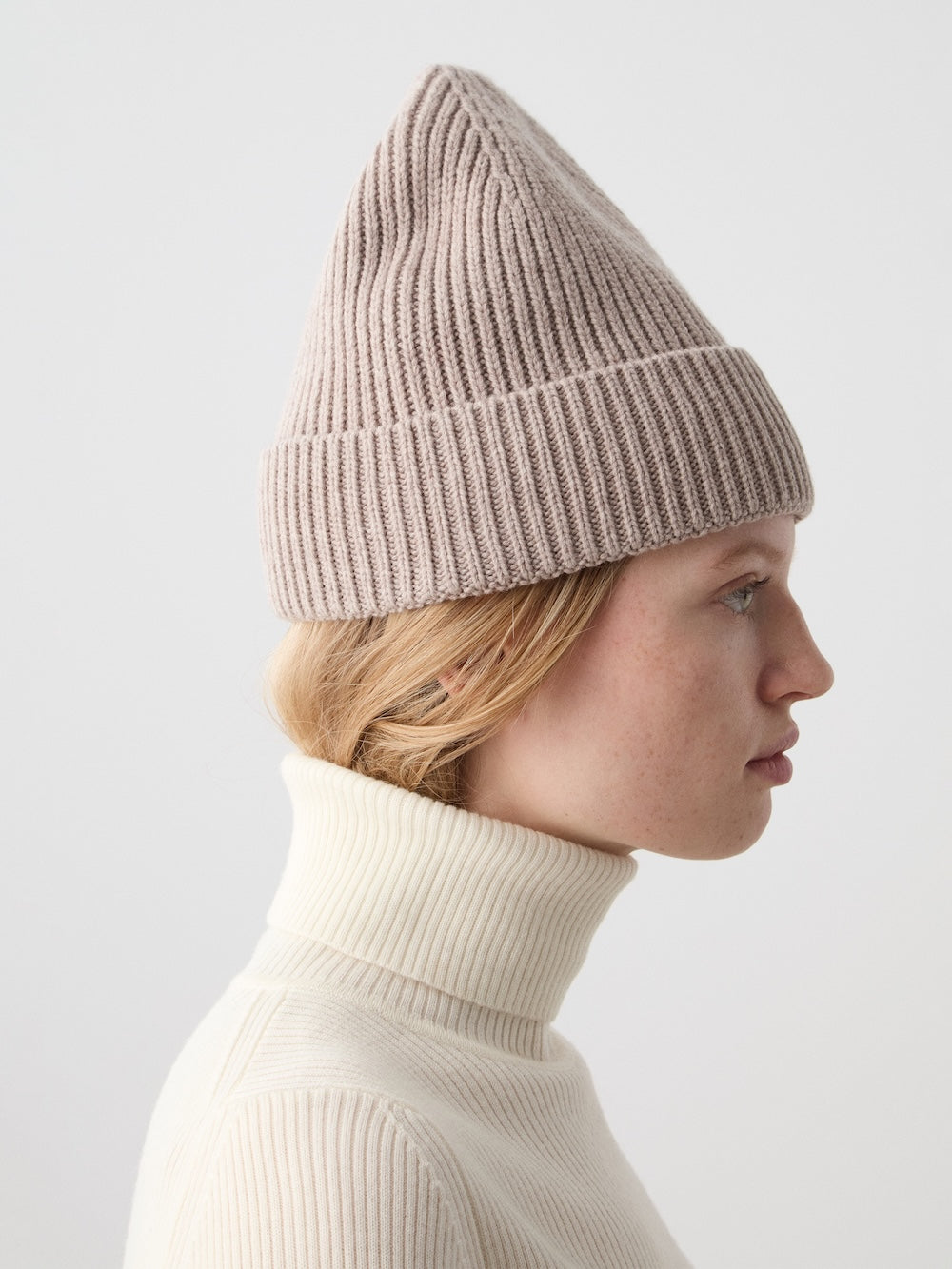 We Norwegians | FW25 | Dal Hat | Model wearing a knit beanie in sand on an off-white background