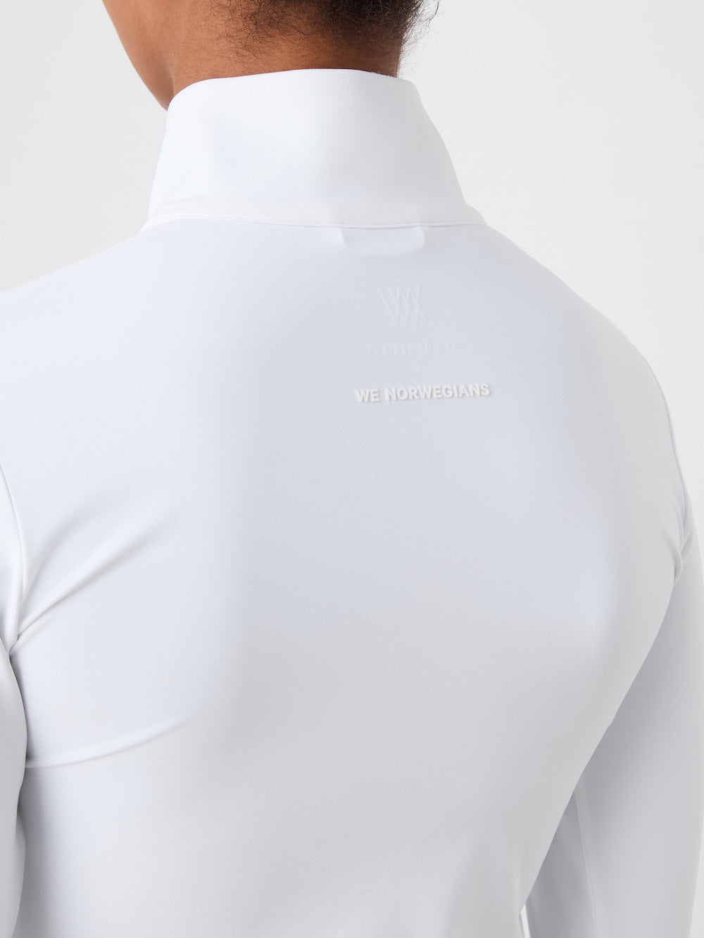 White long-sleeve shirt with a brand logo on the back against a light background