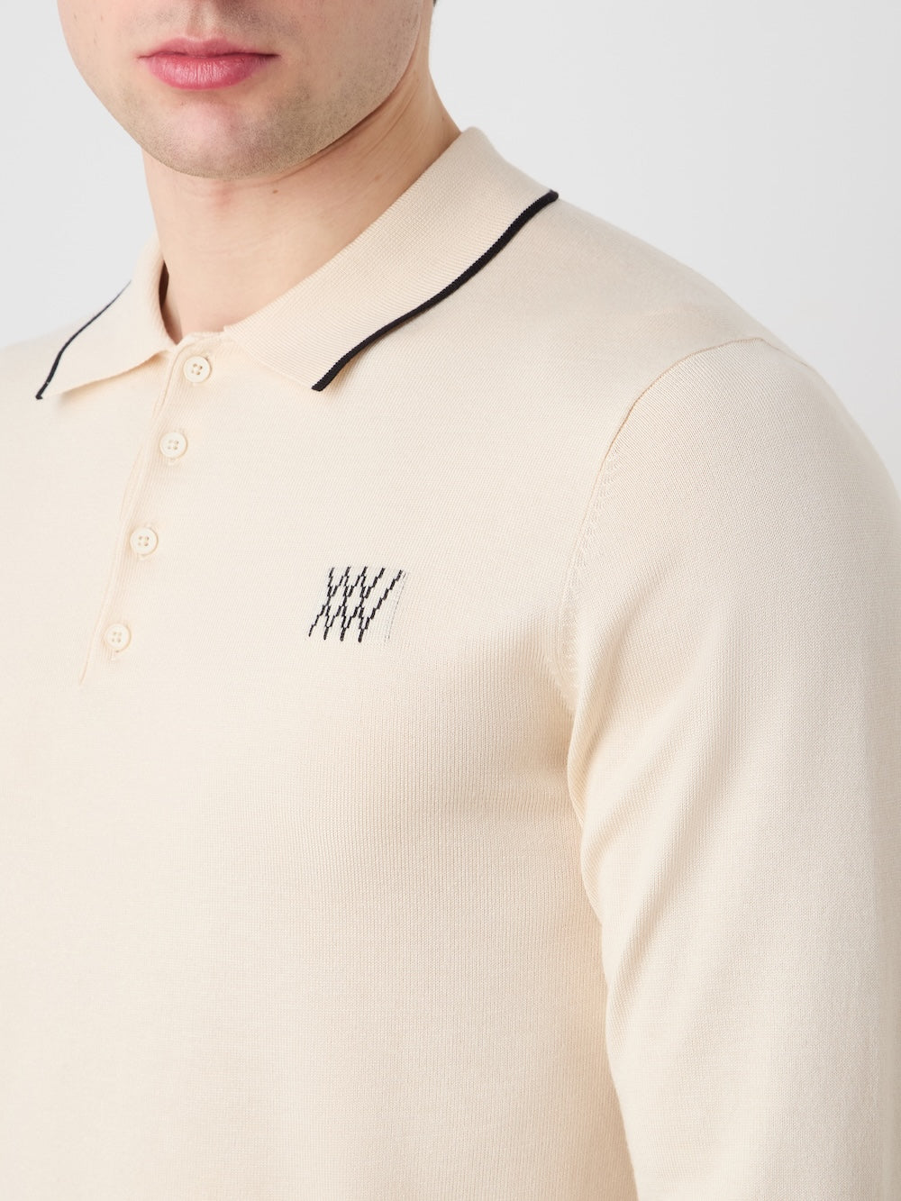 Beige long-sleeve polo shirt with black details on a light background