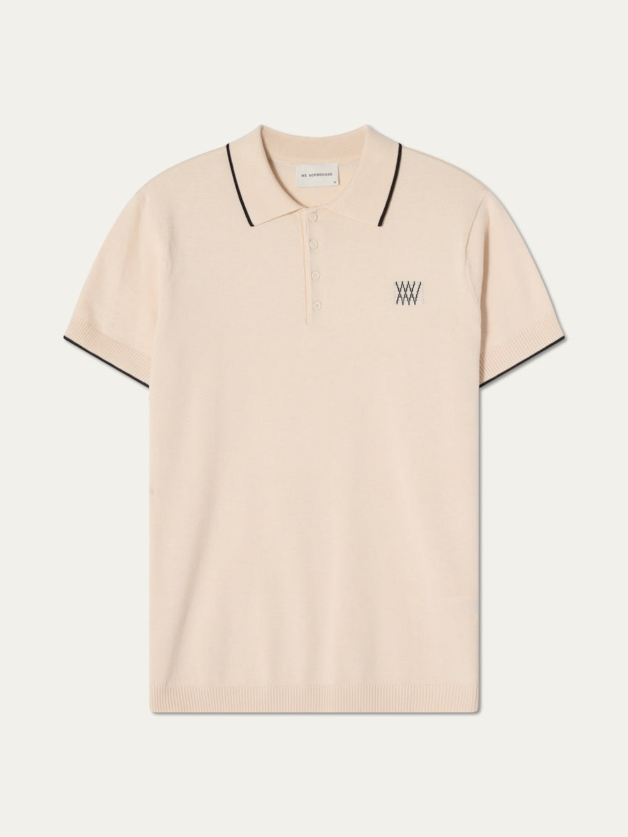 Beige polo shirt with black trim on an off white background
