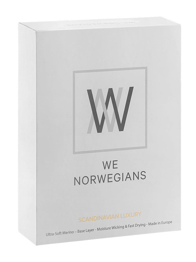 A product box with a minimalist design primarily in light grey. The center of the box features a logo with the intertwined letters "WW" above the brand name "We Norwegians". At the bottom, text reads "Scandinavian Luxury", highlighting the Sno Merino Tee Men, merino wool, and Creora-Eco-Soft base-layers along with product features and origin.